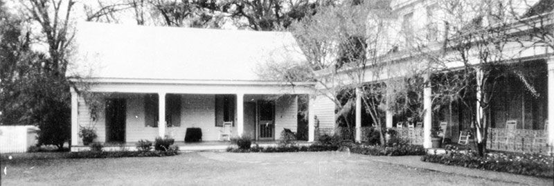 Exterior of The Myrtles Plantation showing a shadowy figure between two of the buildings